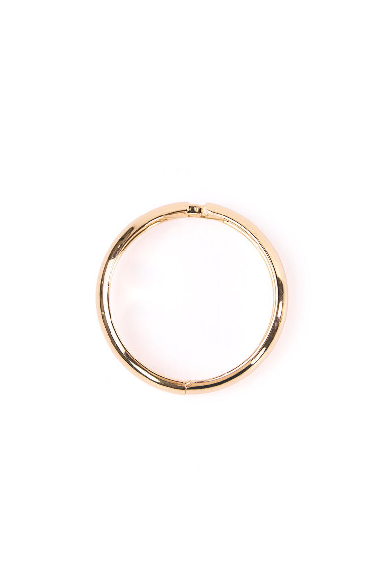 Top view of a shiny gold bangle showing the clasp closure and hinge mechanism