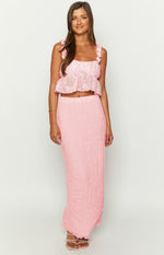Pink crop top with a square neckline, ruffled spaghetti straps, floral textured fabric, and a peplum hem