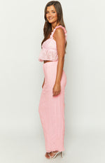 Side view of the pink floral textured crop top with ruffled shoulder straps and a flared peplum hem