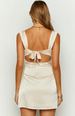 Rear view of the cream satin mini dress with wide shoulder straps, a bow tie-back, and open back