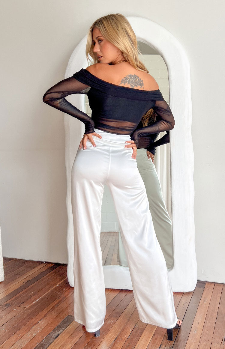 Rear view of white wide-leg pants with a smooth, lustrous fabric and relaxed fit