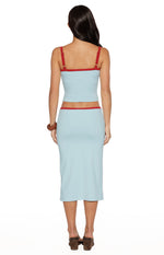 Rear view of a light blue cropped tank top with red trim on the neckline and hem, and red adjustable spaghetti straps
