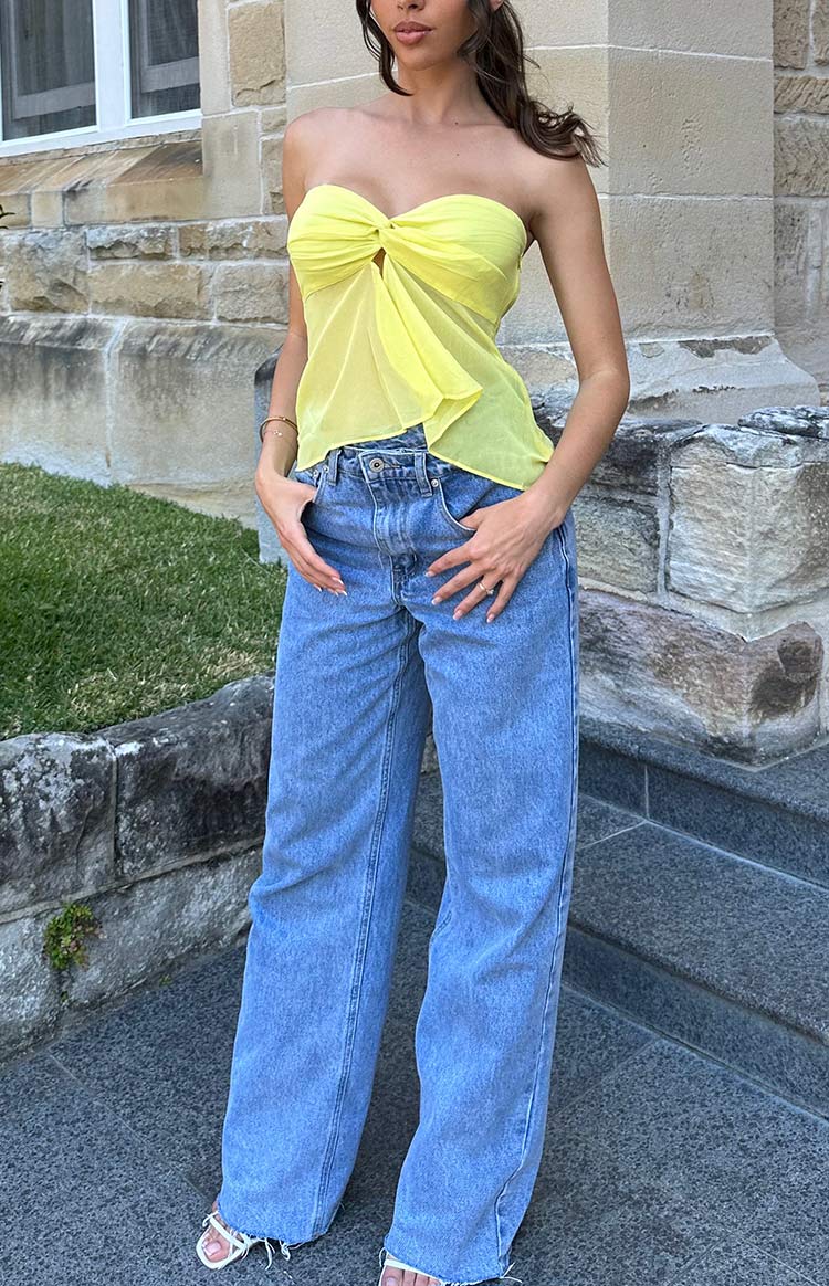 Light blue wide-leg jeans with a unique uneven crossover waist and relaxed fit