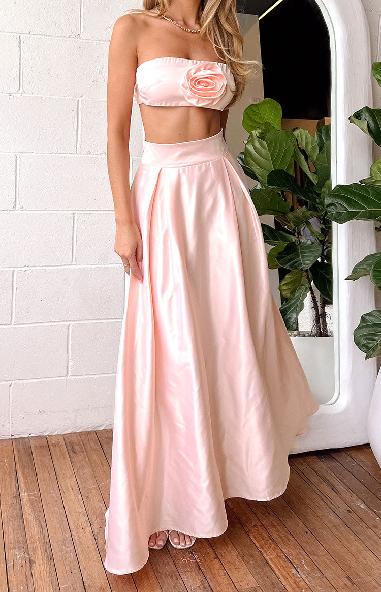 Pink satin high-waisted maxi skirt with a full, flowing silhouette and pleats