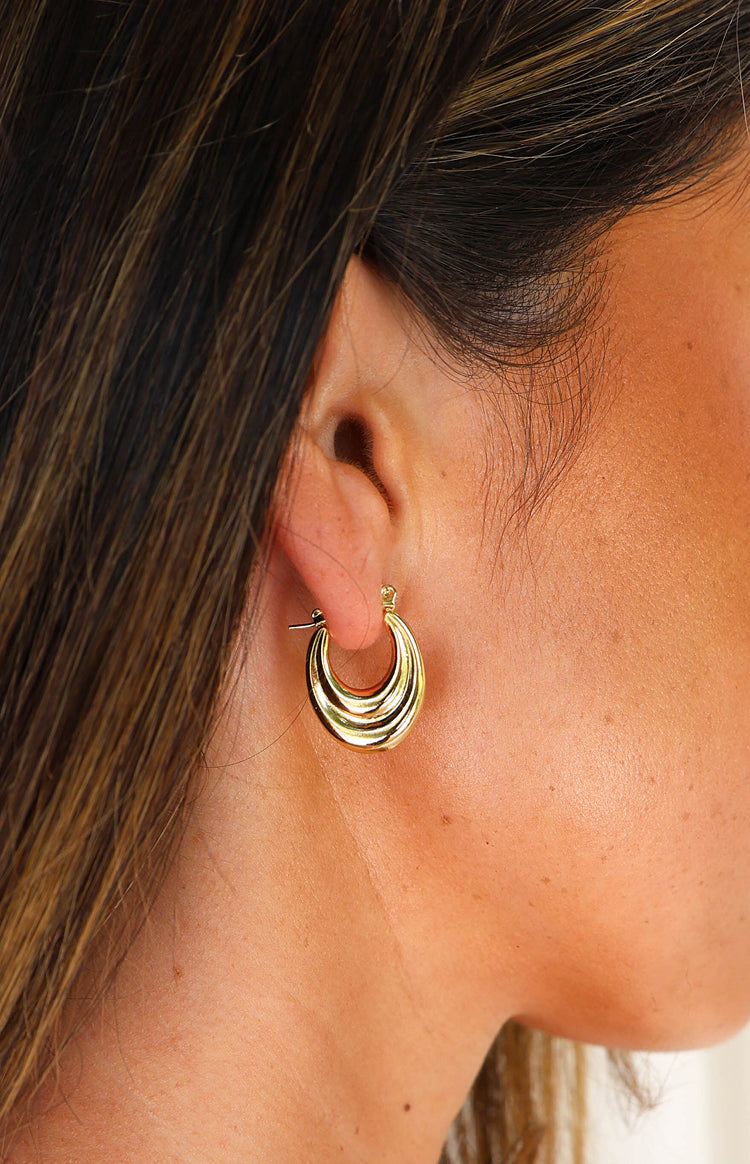 Side view of a gold hoop earring with a thick, ridged design and a visible post-back closure