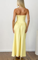 Rear view of a yellow strapless maxi dress with a fitted bodice and gathered flowing skirt