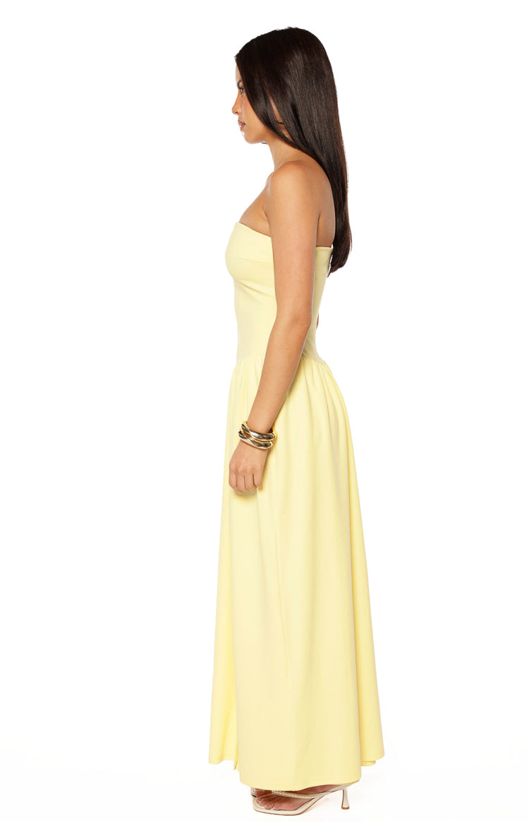 Side view of the yellow strapless maxi dress, highlighting the structured bodice and gathered waist