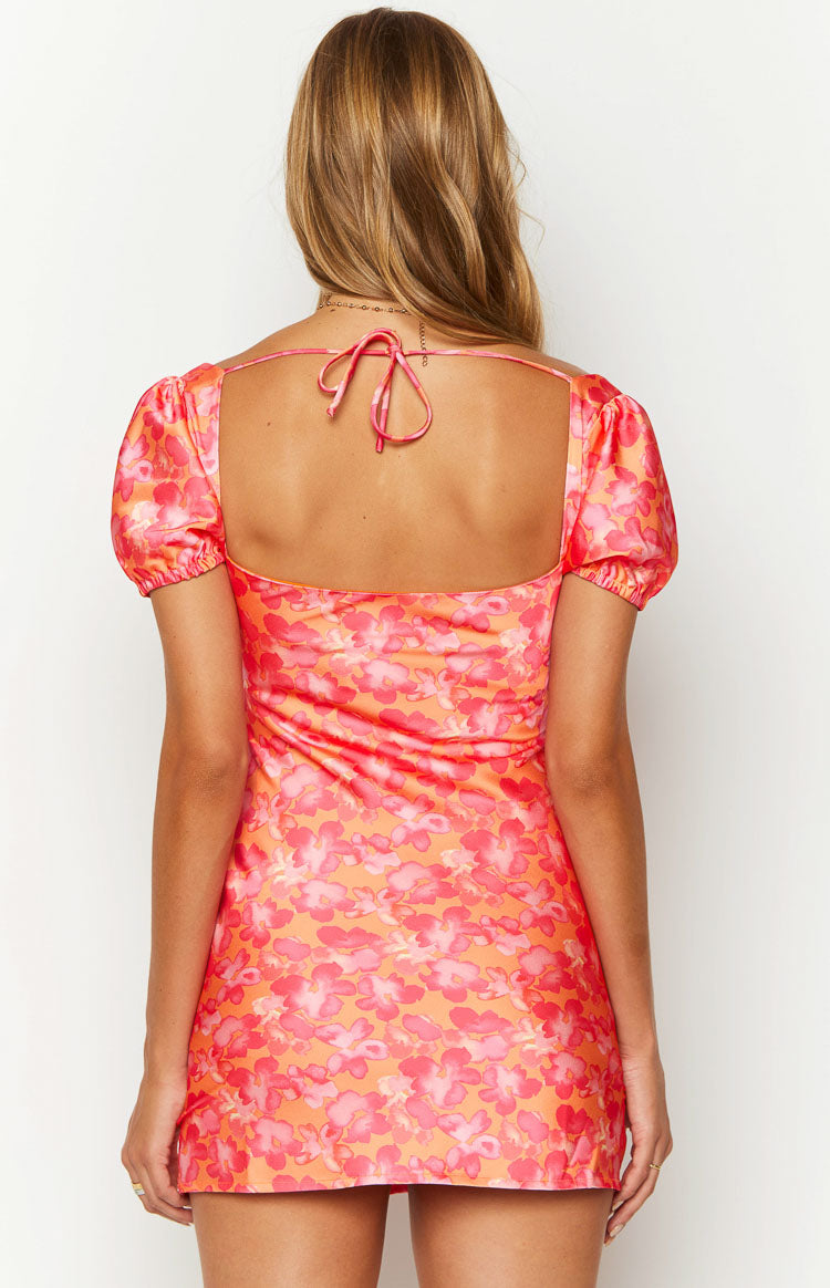Back view of an orange floral print mini dress with a square neckline, tie-back, and short puff sleeves