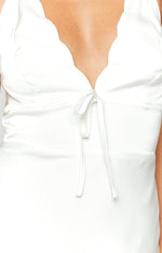 Close-up of the white dress's scalloped neckline and tie-front bust detail
