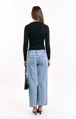 Rear view of a black ribbed knit long sleeve sweater with a collared neckline and fitted silhouette