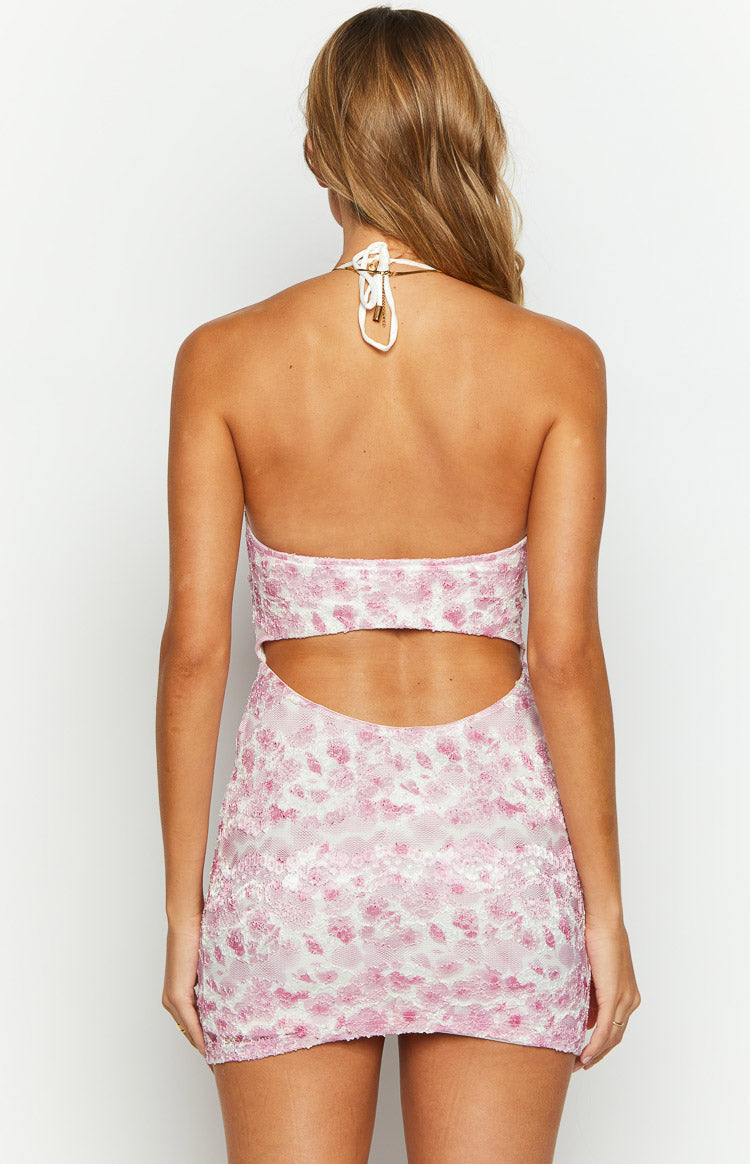 Back view of the pink lace mini dress showing the halter neck tie and open waist cutout