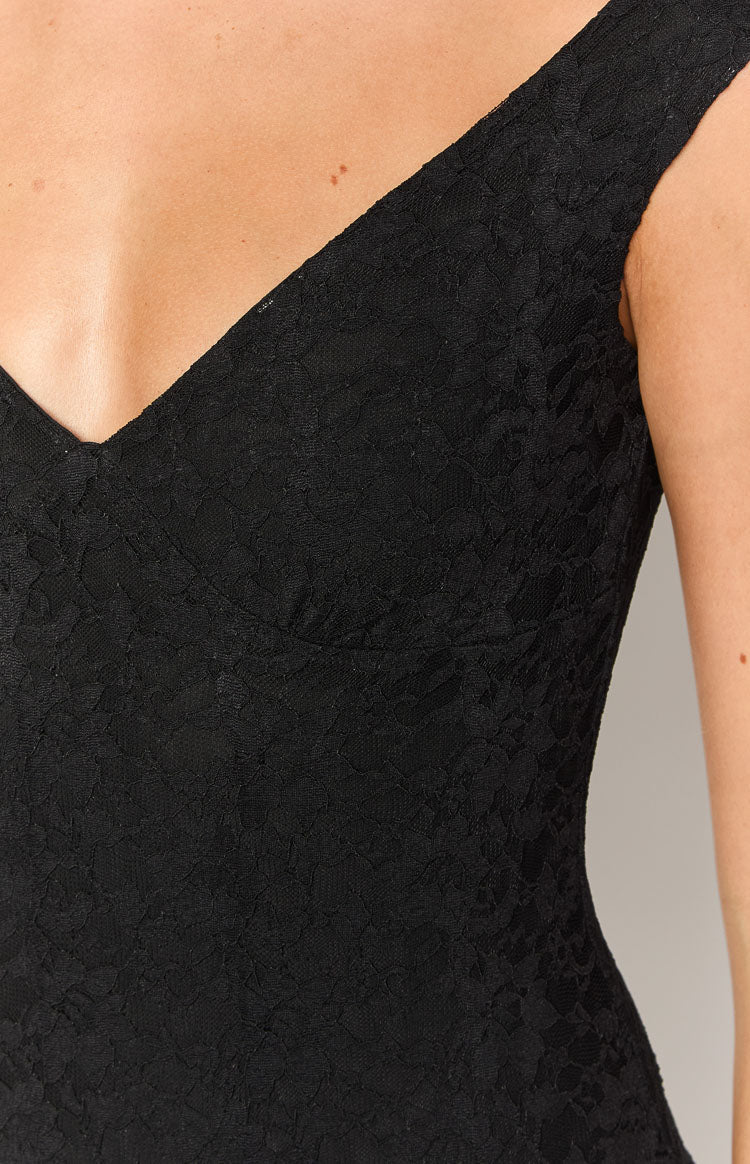 Back view of the black textured mini dress featuring a deep V-neckline and short cap sleeves
