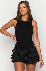 Black ribbed knit sleeveless playsuit with a round neck and tiered ruffle shorts