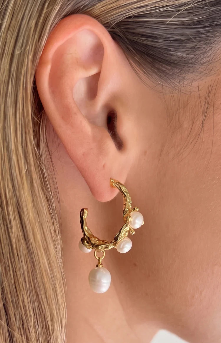 Close-up of the organic textured gold hoop earring featuring three embedded freshwater pearls and one dangling pearl