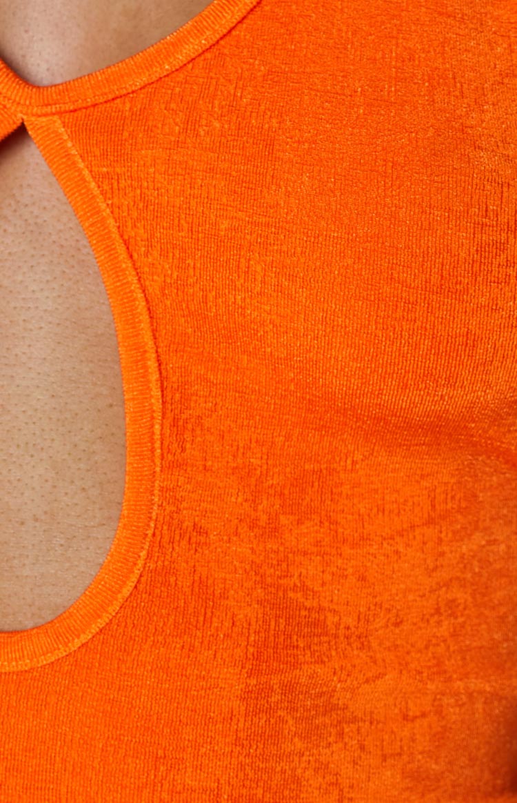 Side view of an orange backless midi dress with a halter neck tie and a high side slit