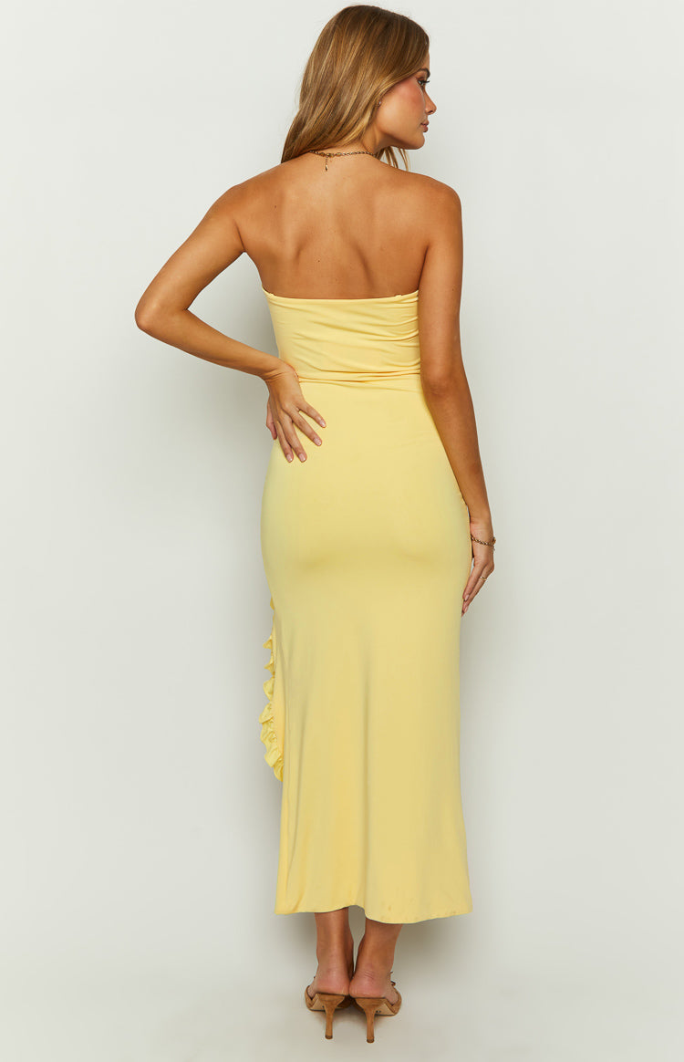 Yellow strapless maxi dress with a high leg slit, ruffled trim, and a small fabric rose detail