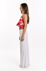 Side view of the yellow orchid print cowl neck top with a draped front and side tie detail