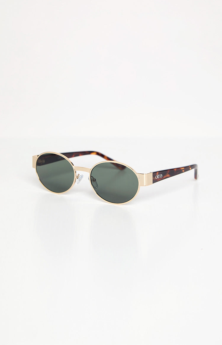 Angled view of gold framed round sunglasses with dark lenses, showing tortoiseshell arms and brand logo