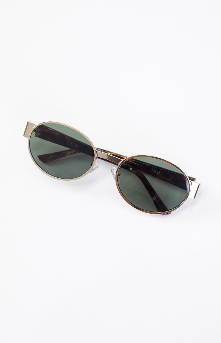 Angled view of gold framed round sunglasses with dark green lenses and tortoiseshell patterned temples