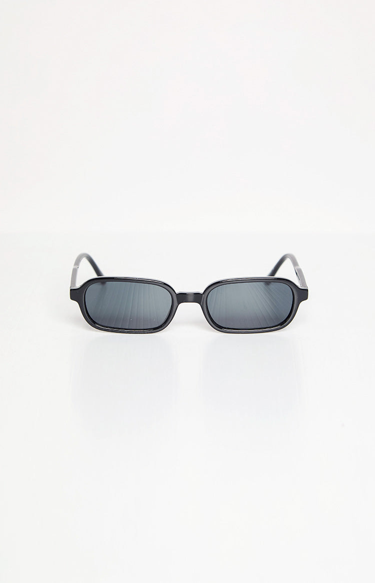 Angled view of black rectangle sunglasses with dark lenses and thick frames, showing the OTRA logo on the arm