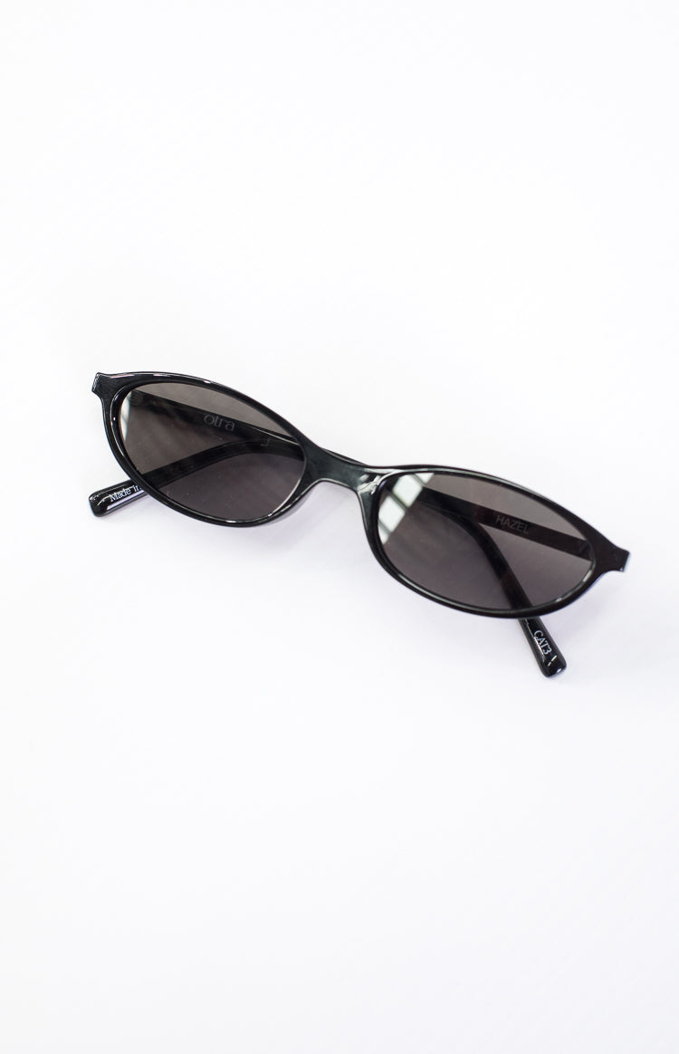 Side view of black cateye sunglasses with dark lenses and 'otra' logo on the temple arm