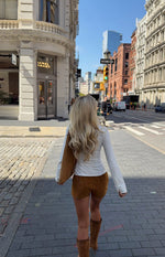 Rear view of the fitted tan suedette shorts, highlighting the short hemline and smooth suedette texture