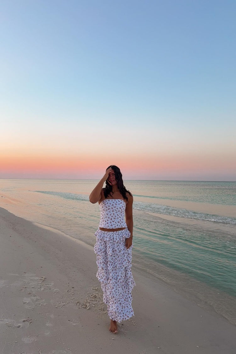 Full length view of a white floral maxi skirt with multiple tiered ruffles and a flowy silhouette