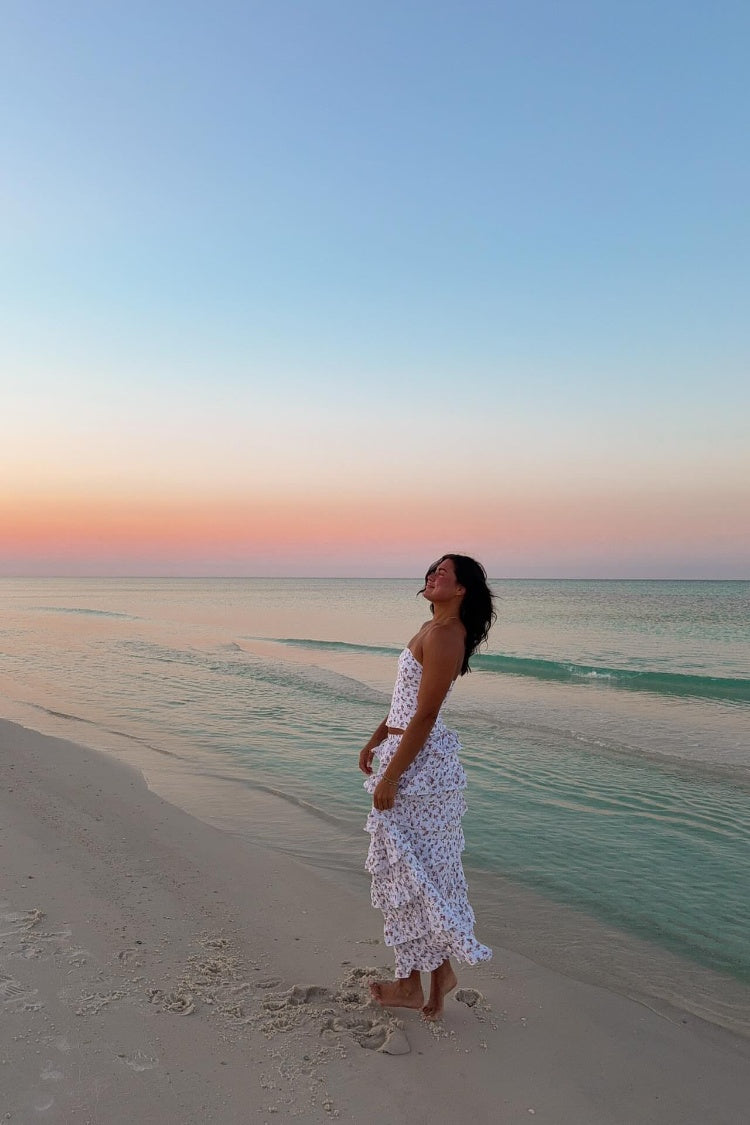 Side view of a white floral print maxi skirt with multiple tiers of gathered ruffles