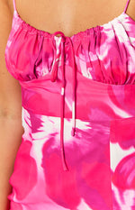 Close-up of the ruched bust and tie-front detail of a pink and white abstract print midi dress