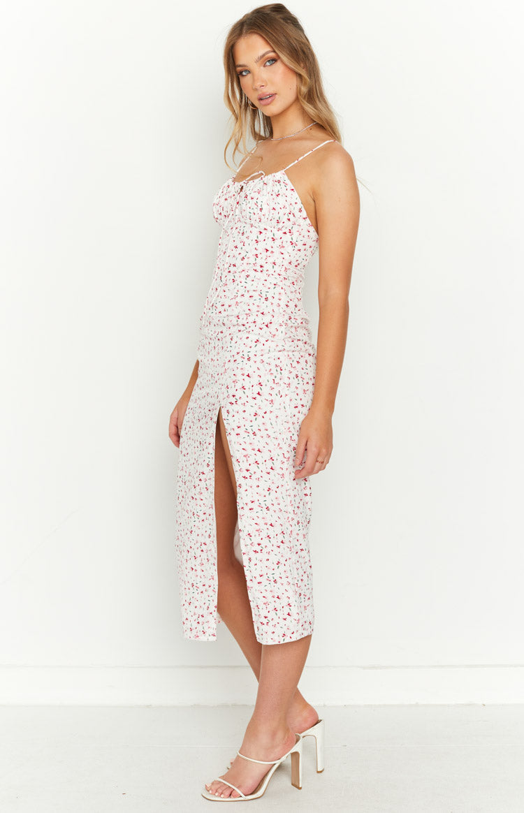 Side view of a white floral midi dress with spaghetti straps, ruched bust, and a high side slit