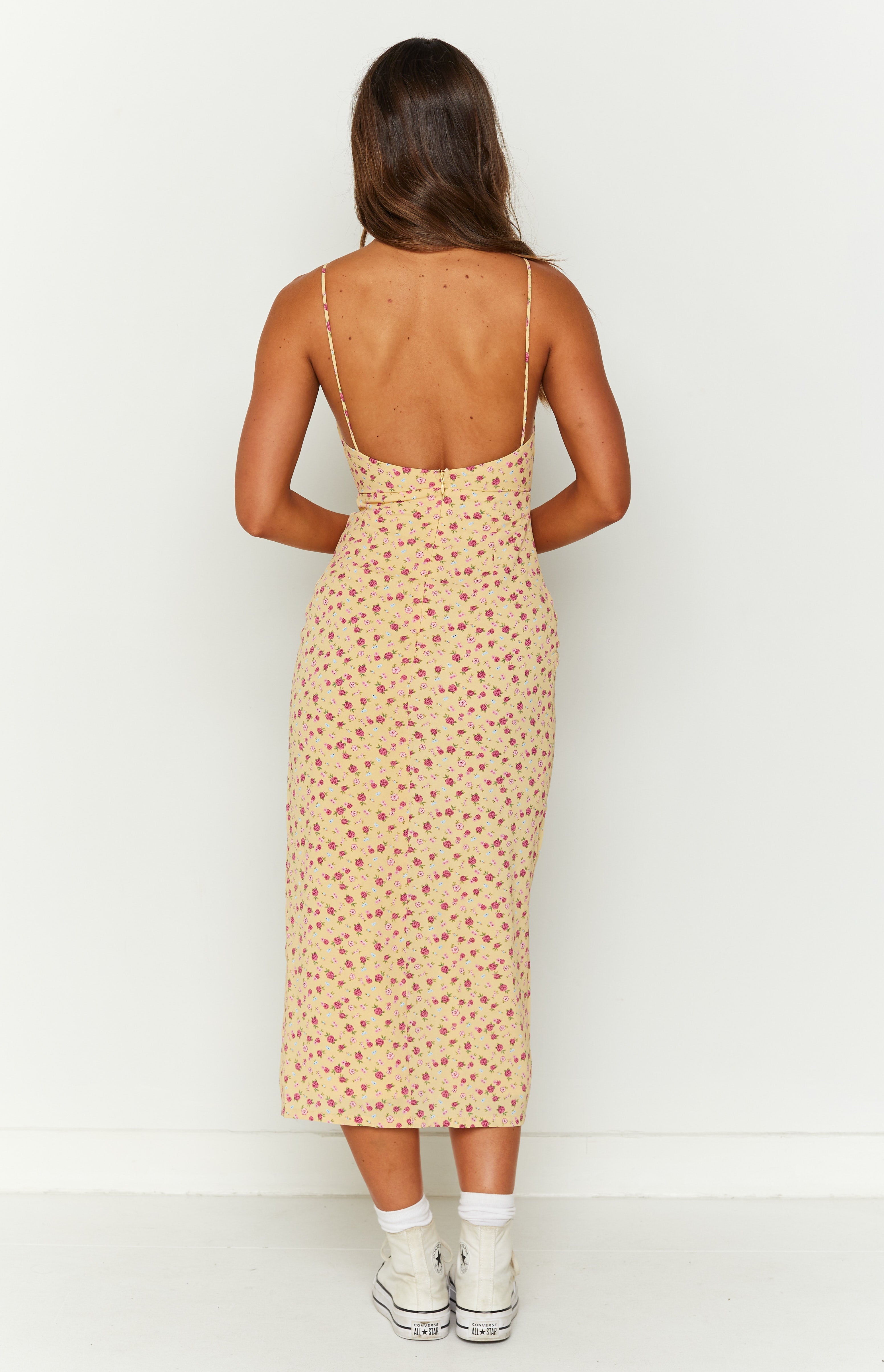 Rear view of a yellow floral midi dress with pink and blue flowers, thin spaghetti straps, low scoop back, and invisible zipper