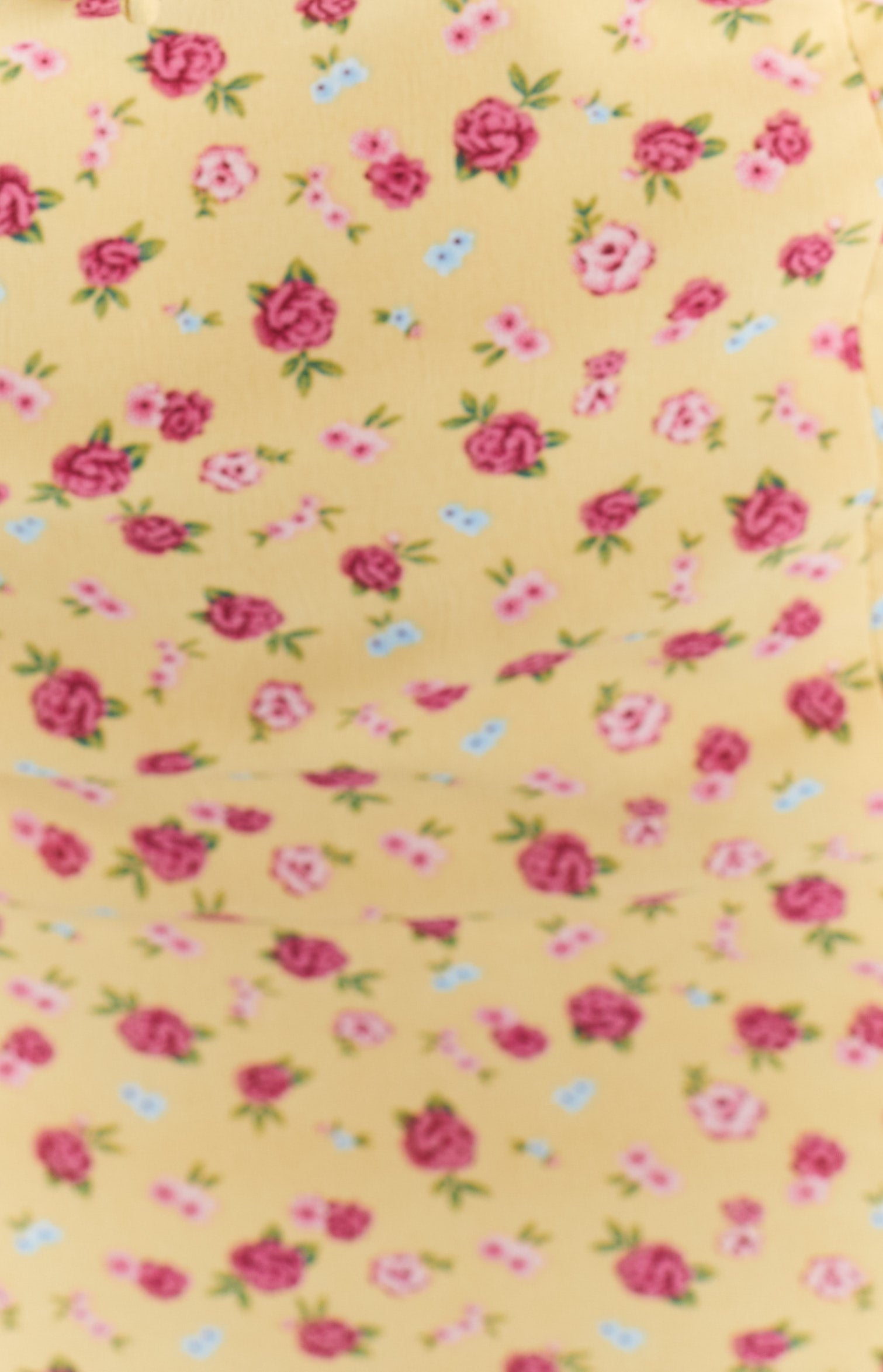 Close-up of the yellow floral midi dress fabric with pink and red roses and small blue flowers