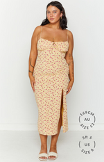 Front view of a yellow floral midi dress with a sweetheart neckline, ruched bodice, and a high left leg split