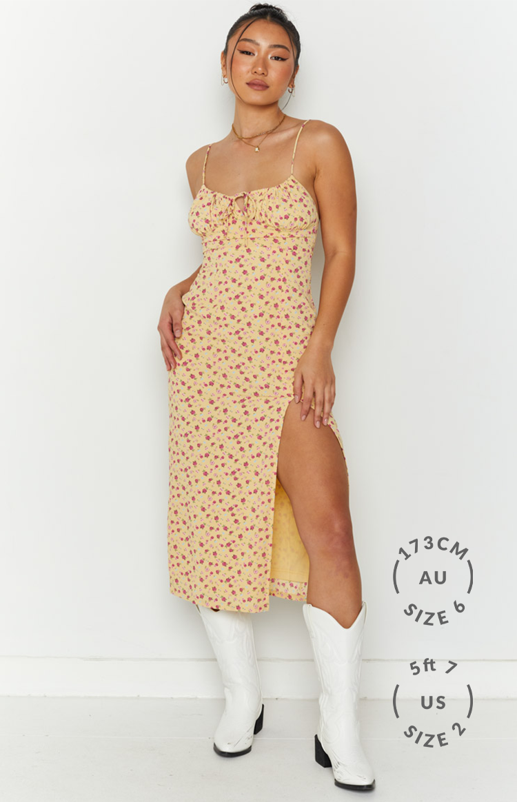 Front view of a yellow floral midi dress with a tie-front sweetheart neckline and high thigh split