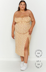 Yellow floral midi dress with a sweetheart tie-front neckline, thin straps, and a high side slit
