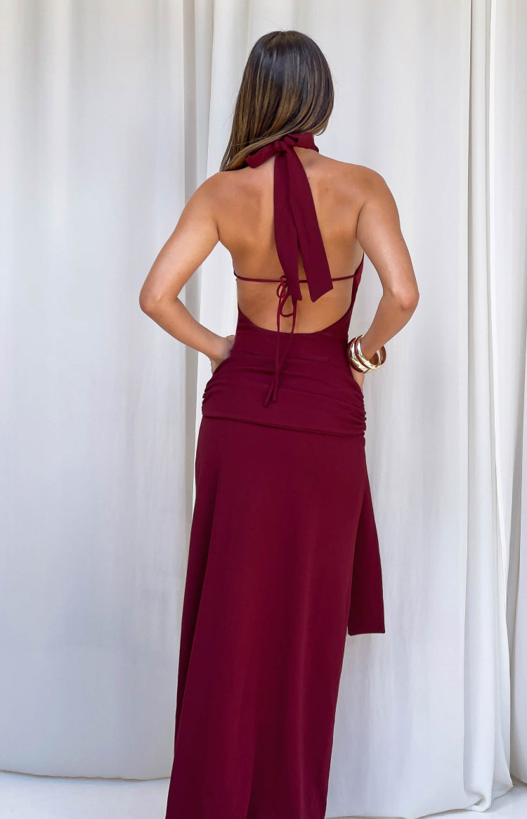 Rear view of a burgundy jersey formal dress showing the halter neck tie, open back, thin tie straps, and ruched detail