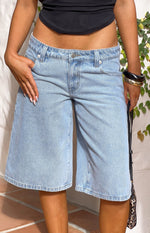 Front view of light wash denim shorts with a low-rise waist, button closure, and wide-leg knee-length cut