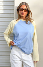 Front view of a blue and yellow contrast raglan sleeve top with a relaxed fit