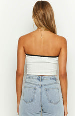 Back view of the white ribbed knit tube top with black contrast binding along the strapless top edge