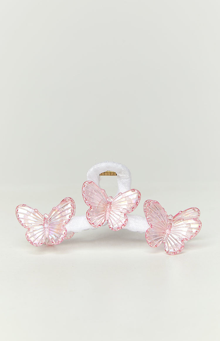 Close-up of the three pink iridescent butterflies on the white claw clip, showing the gold spring