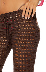 Close-up of the brown crochet pants showing the drawstring waist and side strap with metal rings