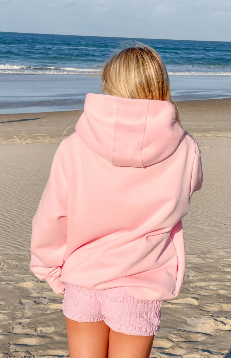 Rear view of a light pink relaxed fit hoodie with a large hood and dropped shoulders