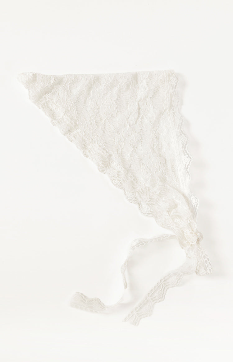 Flat lay of a white lace triangle scarf with delicate floral pattern and scalloped edges, showing tie straps