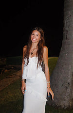 White strapless top with a tie-front bust and tiered ruffles flowing down the bodice