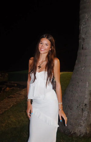 Close-up of the white maxi skirt showing the delicate diagonal ruffle and the upper layered ruffle