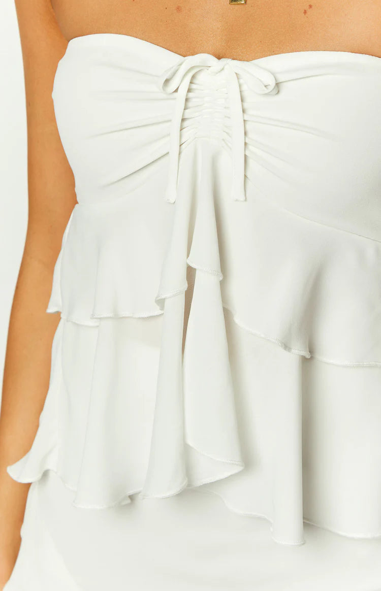 Close-up of the white strapless top showing the ruched drawstring bust and tiered ruffles