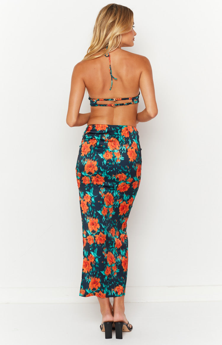 Side view of a dark floral maxi skirt with orange and teal flowers, featuring a high side slit and ruched drawstring detail