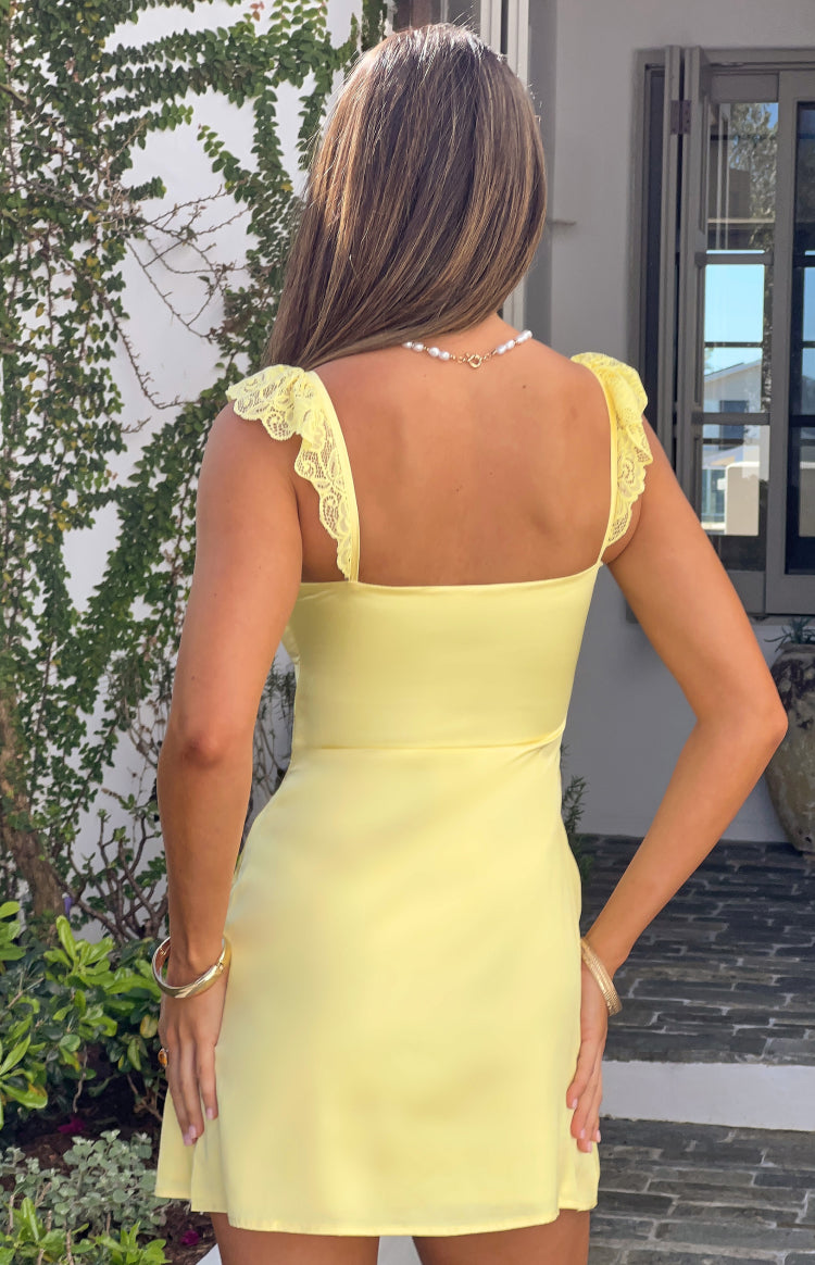 Rear view of a yellow mini dress with lace flutter shoulder straps and a straight back neckline