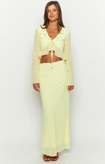 Full-length view of the yellow maxi skirt with a ruched side detail and a sheer, flowing hem