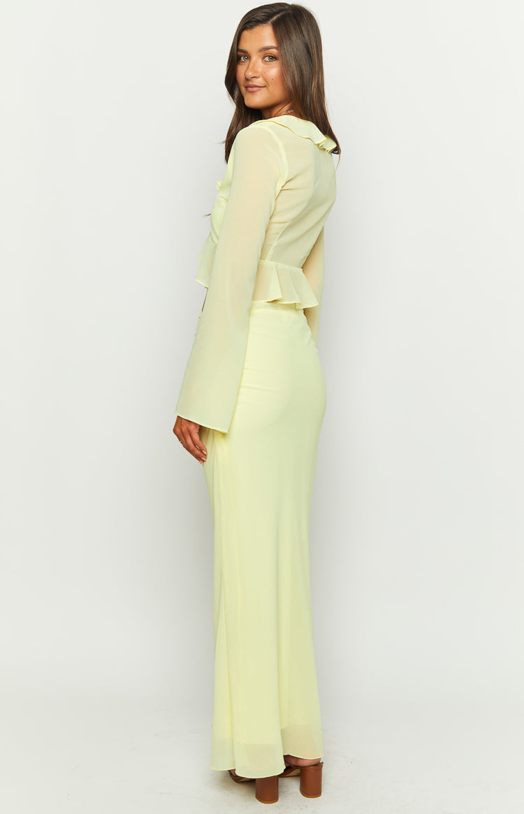 Side view of a pale yellow maxi skirt with a fitted waist and flowy sheer fabric